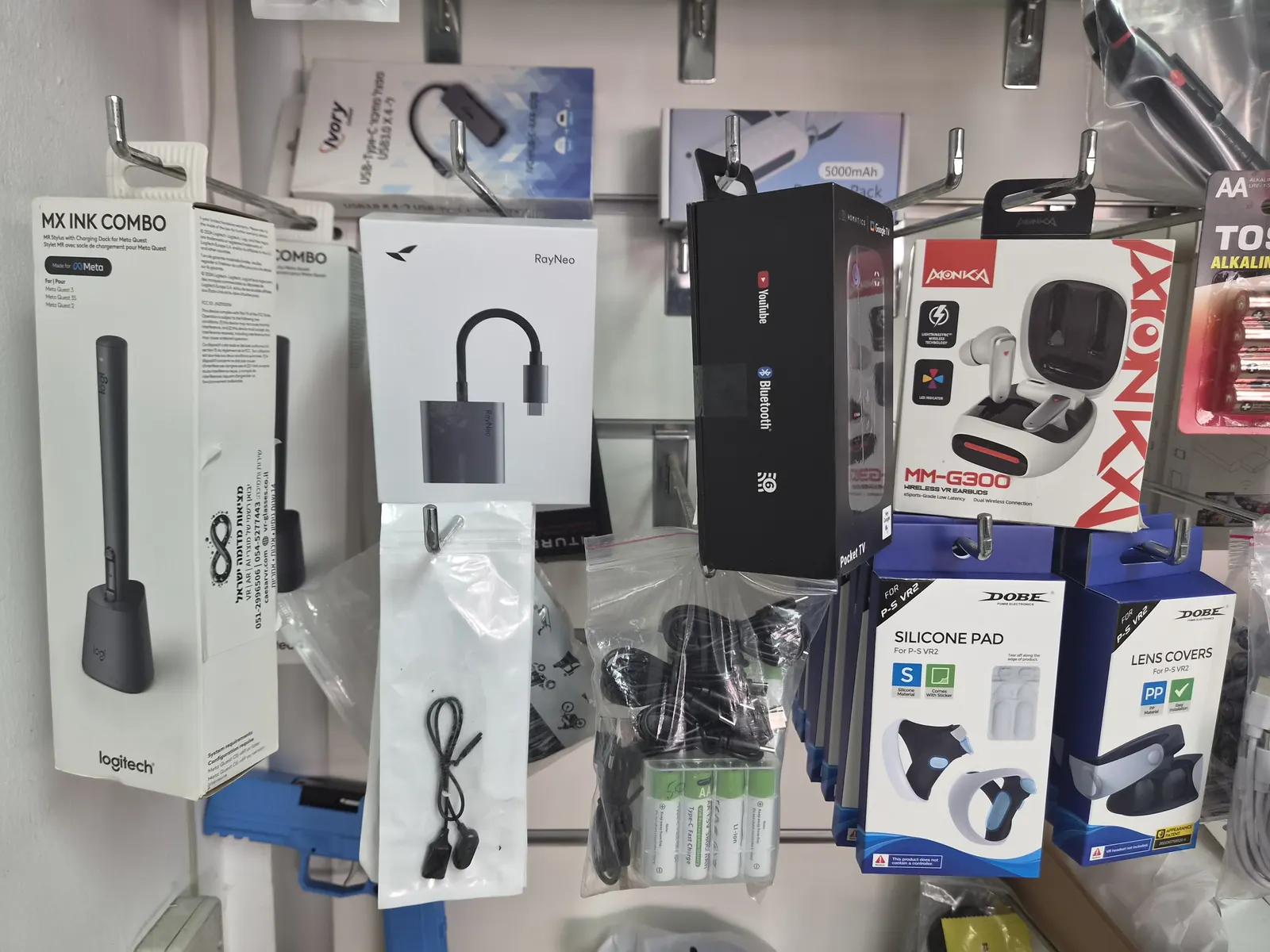 מוצרים על מתלים באולם, כולל Logitech MX Ink ו-RayNeo
